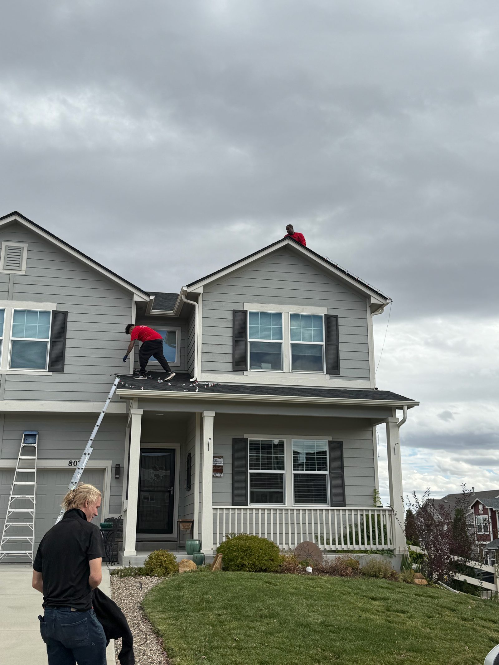 Front Range company crew installing warm white C9 Christmas lights on a two-story home roofline Front Range company crew installing warm white C9 Christmas lights on a two-story home roofline